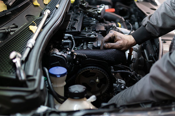 Mechanic working on engine in car