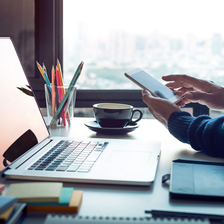 iPhone and laptop at desk