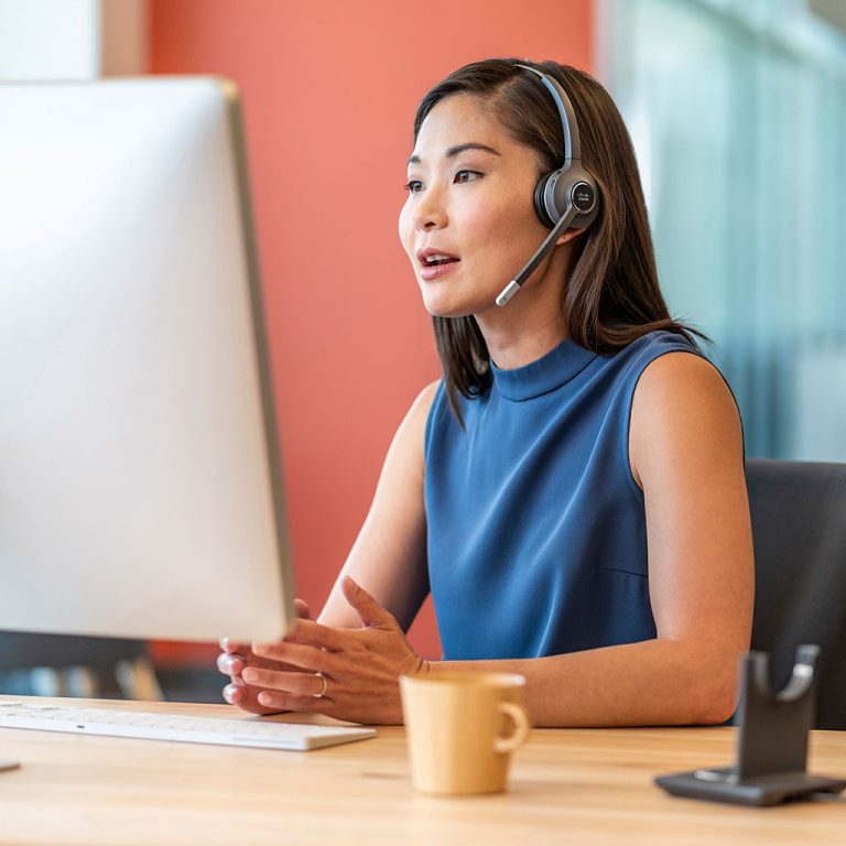 Worker with headset on computer