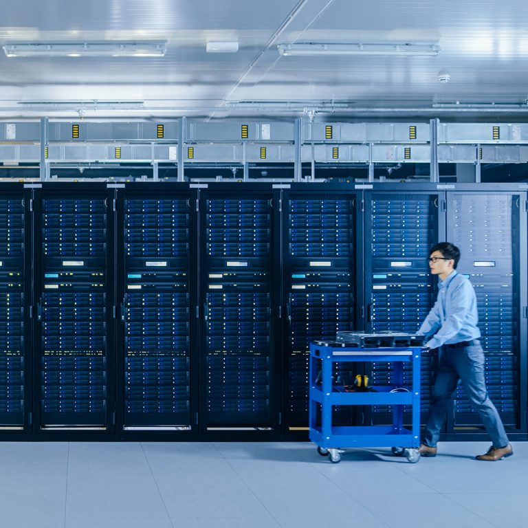 Man pushing cart through server room