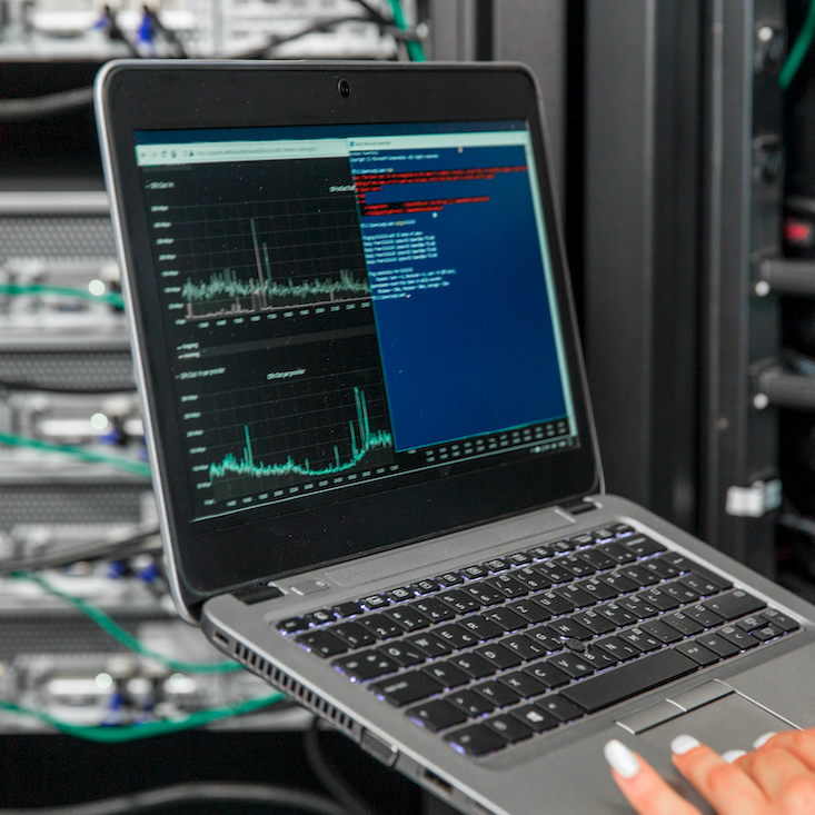 Person on laptop in server room