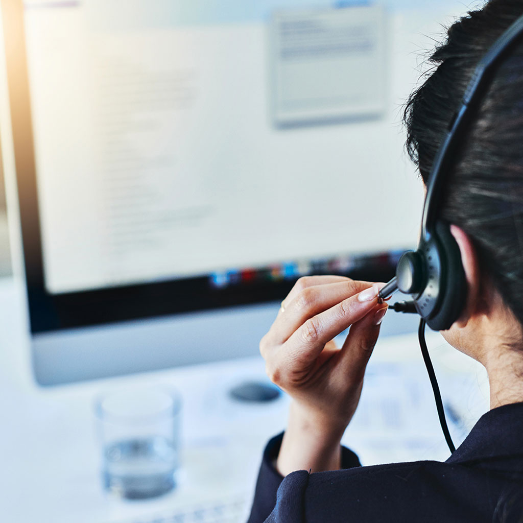 Worker with headset on monitor