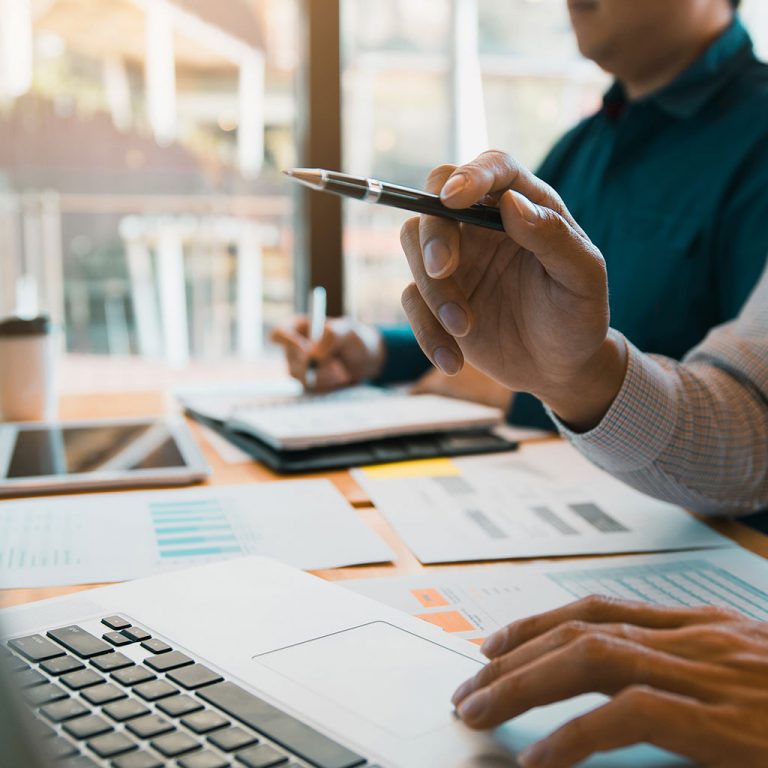 Worker pointing pen at laptop